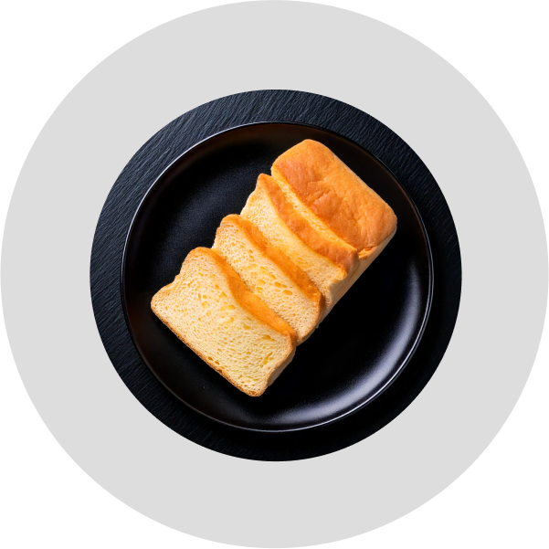 Sliced vanilla loaf bread on black plate, made with Alcirelli’s Pure Vanilla Extract.